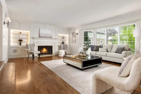 a living room with furniture fireplace and a large window