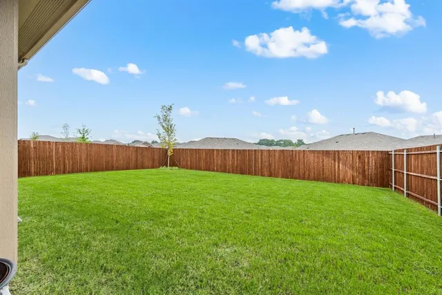 a view of a backyard with a fence