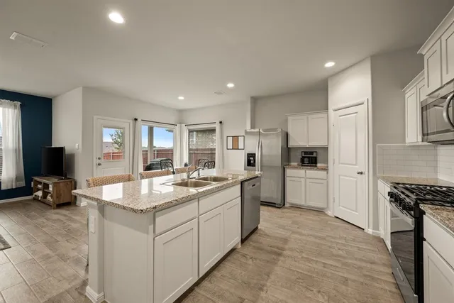 a large kitchen with kitchen island a sink stove and refrigerator