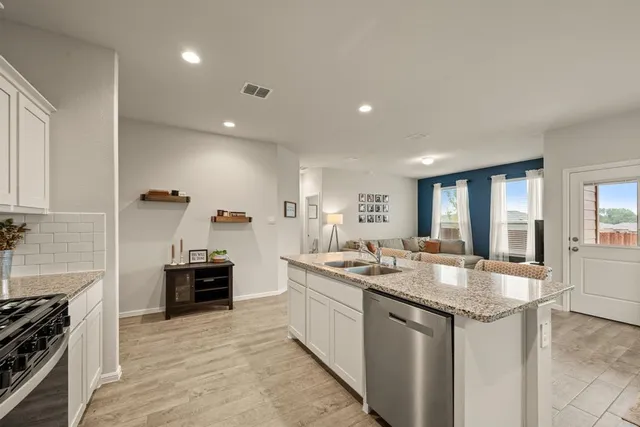 a kitchen with kitchen island granite countertop a sink stove and refrigerator
