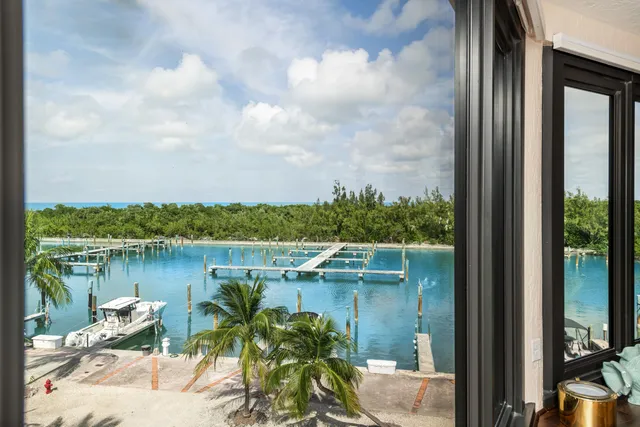 a view of a lake with a floor to ceiling window next to a yard