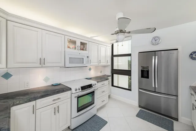 a kitchen with stainless steel appliances a refrigerator sink and cabinets