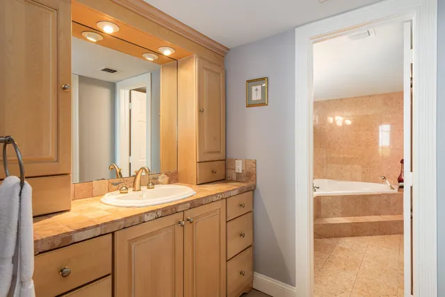 a bathroom with a tub sink toilet and mirror