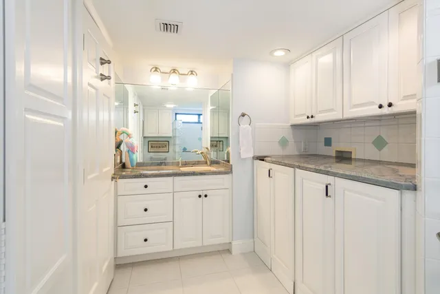 a bathroom with a granite countertop sink a toilet and shower