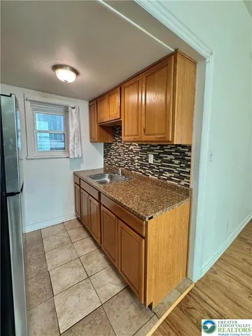 a kitchen with stainless steel appliances granite countertop a sink and a refrigerator