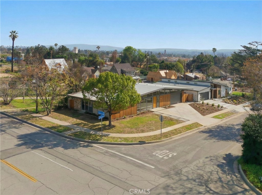 2550 Catherine Road Altadena, CA 91001 - Photo 19 of 65 a view of a white house with a swimming pool and lawn chairs under an umbrella