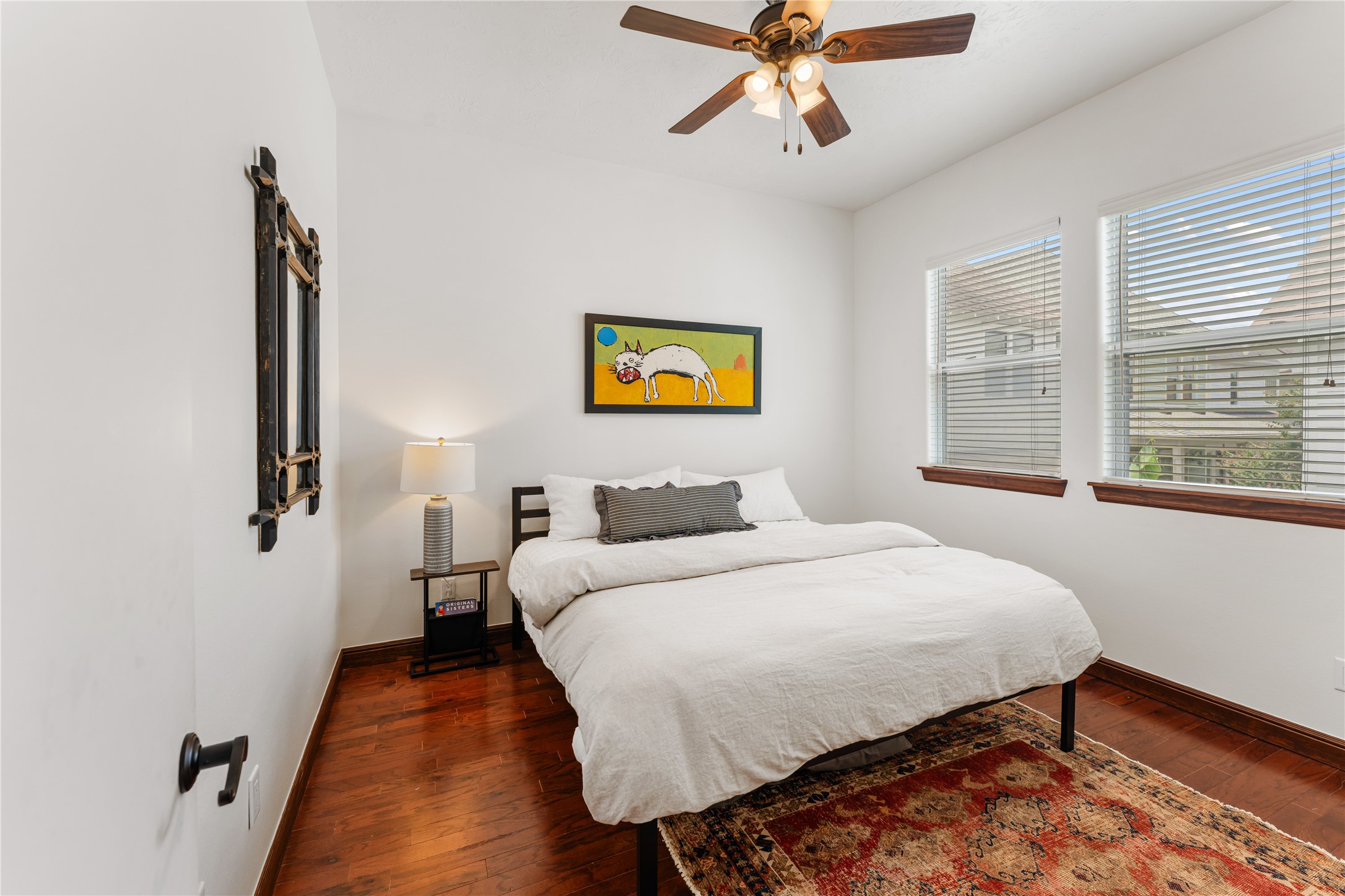 415 West 8th Street Houston, TX 77007 - Photo 31 of 39 This inviting secondary bedroom offers a bright, comfortable retreat with rich hardwood flooring and oversized windows that fill the space with natural light. Its versatile layout easily accommodates guests, family, or a sophisticated home office. Crisp finishes and timeless design make it a seamless extension of the home's elevated aesthetic.