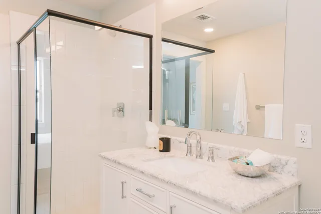 a bathroom with a granite countertop sink and a mirror