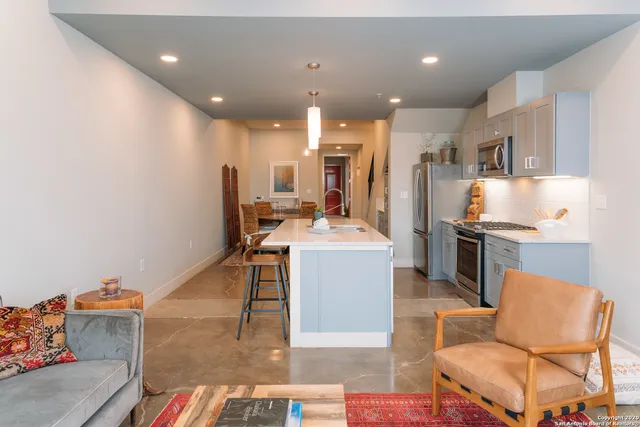a kitchen with kitchen island stainless steel appliances a sink and counter space