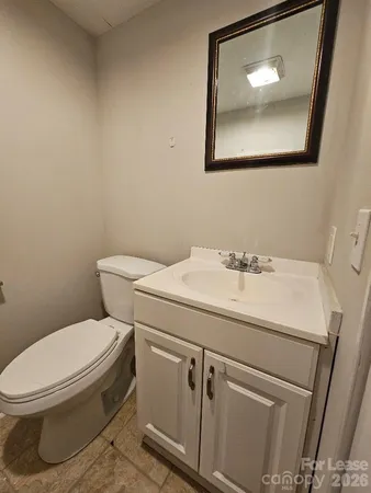 a bathroom with a toilet a sink and mirror