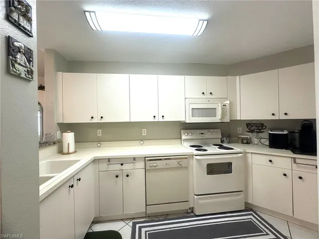 a kitchen with cabinets appliances a sink and a window
