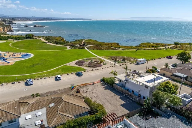 an aerial view of ocean and residential houses with outdoor space