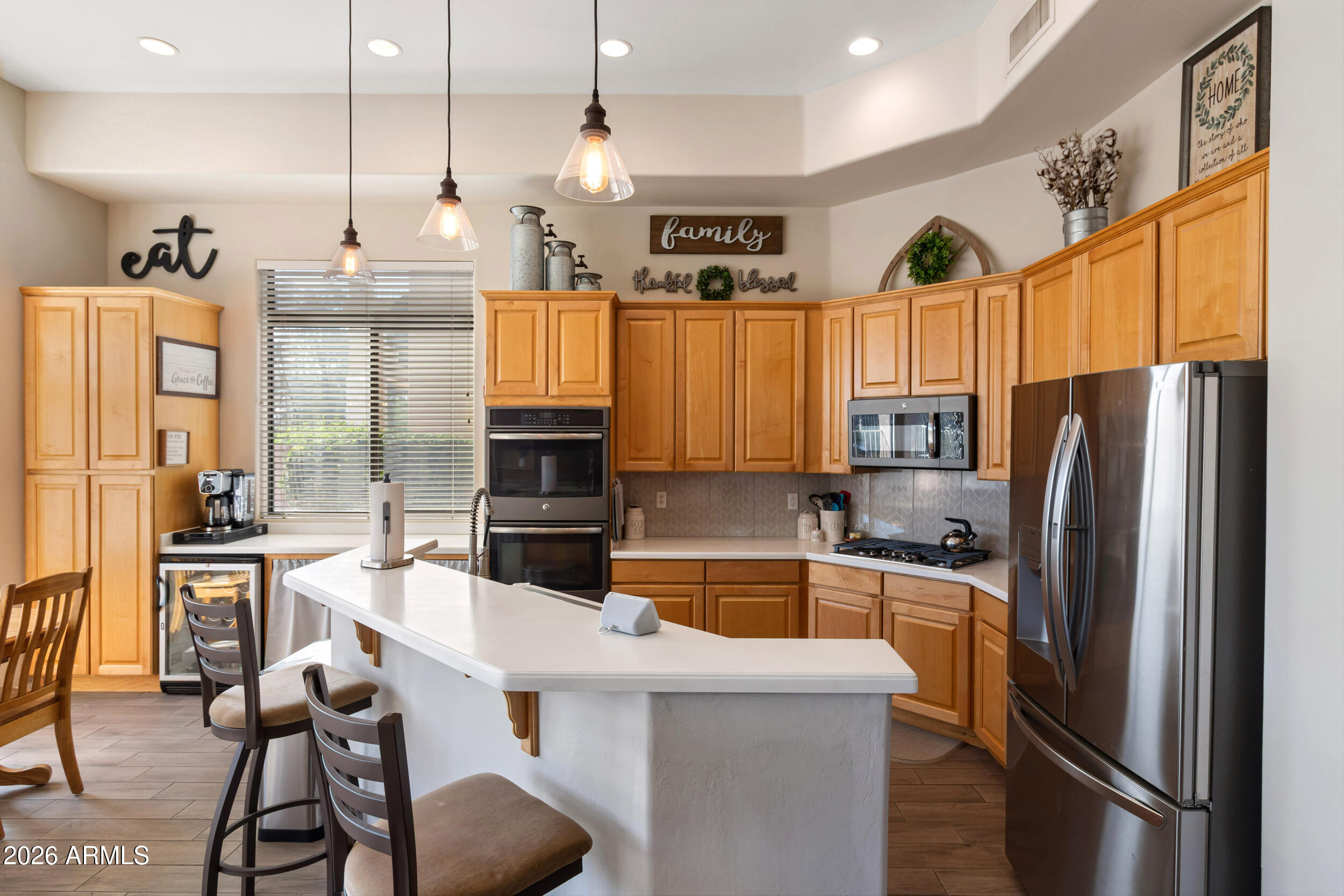 5219 East Hashknife Road Phoenix, AZ 85054 - Photo 11 of 38 a kitchen with stainless steel appliances a refrigerator a stove a sink a dining table and chairs with wooden floor