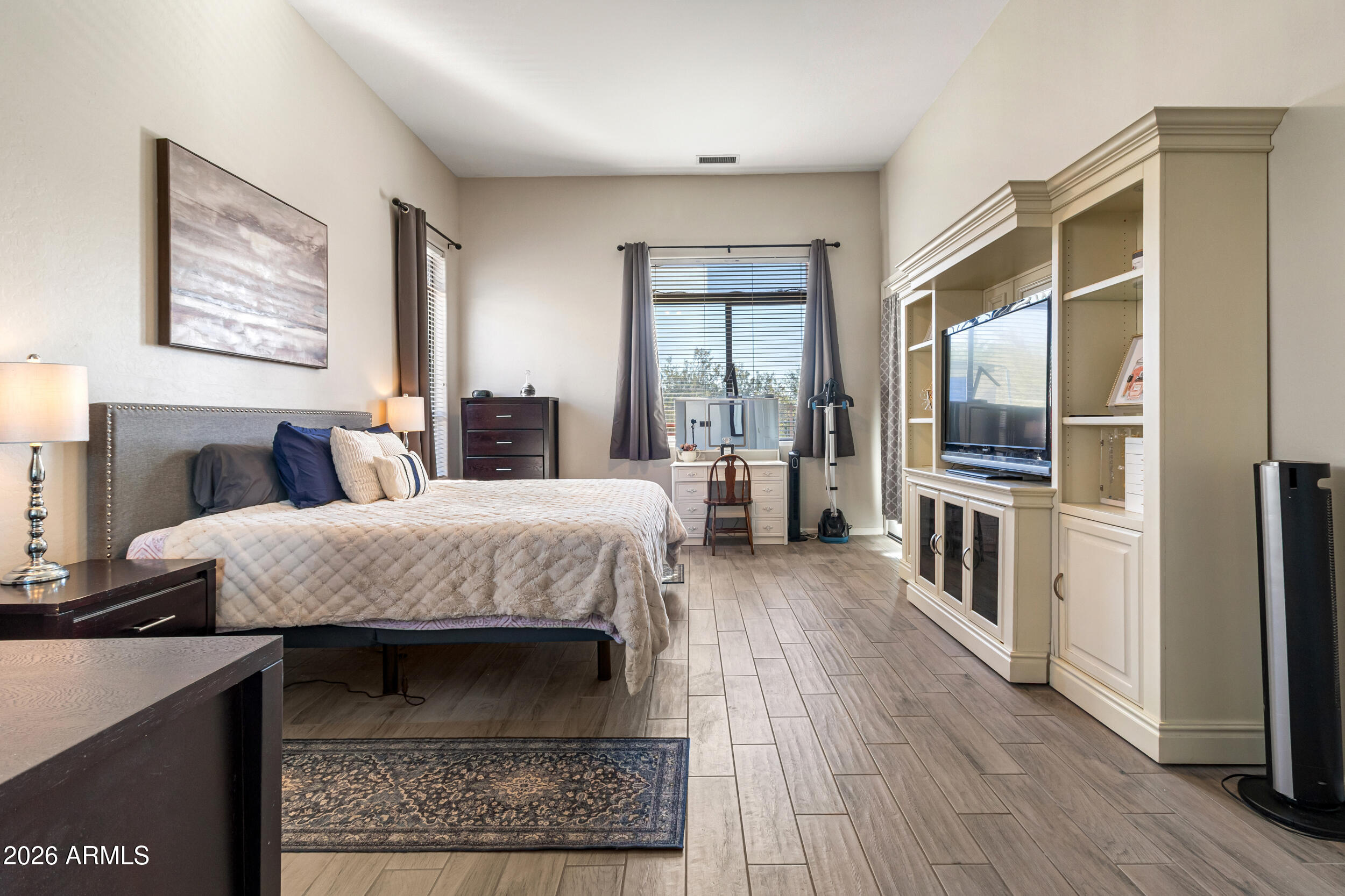 5219 East Hashknife Road Phoenix, AZ 85054 - Photo 15 of 38 a bedroom with a bed a mirror and wooden floor