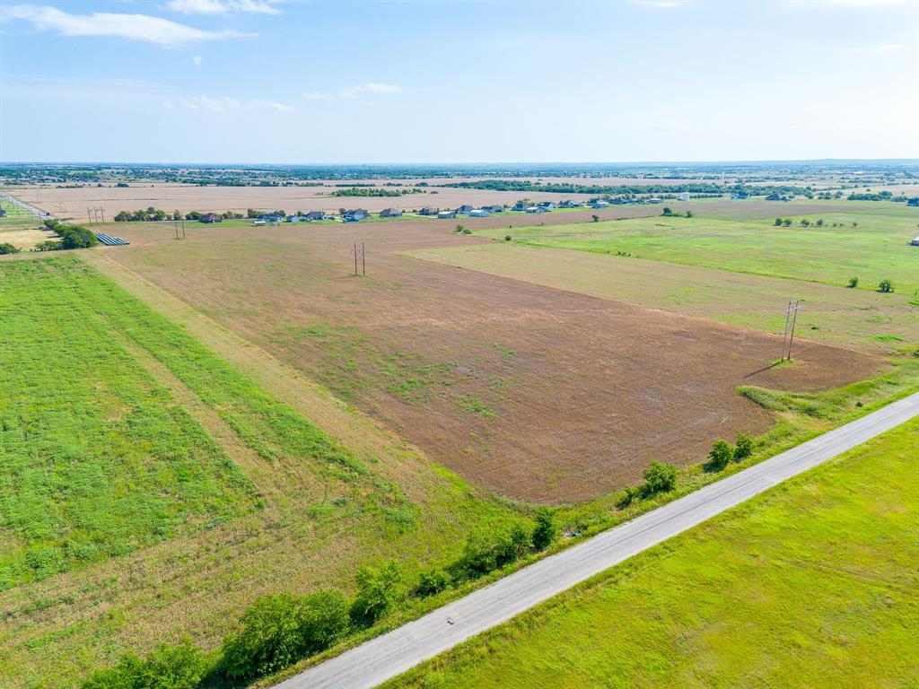6785 Hoehn Road Valley View, TX 76272 - Photo 6 of 14 Expansive agricultural land featuring a gravel road, open fields, and distant residential structures