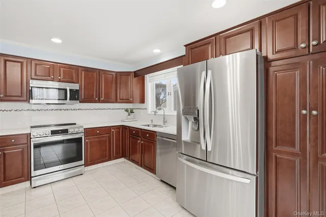 a kitchen with granite countertop wooden cabinets and stainless steel appliances