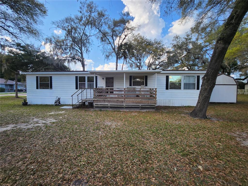 6091 Southeast 114th Street Road Belleview, FL 34420 - Photo 1 of 44 a front view of house with yard tub and trees in the background