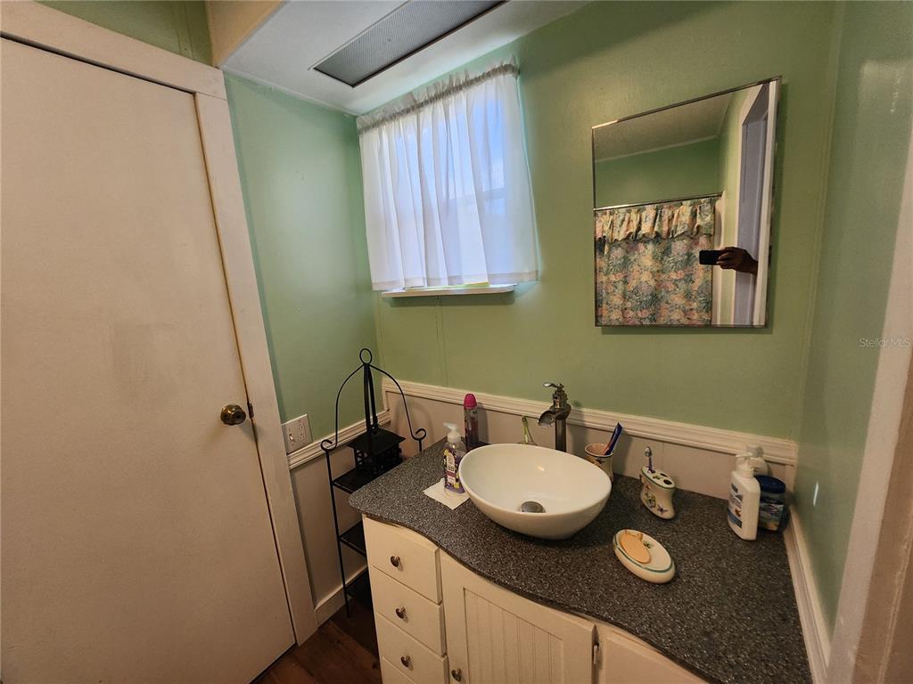 6091 Southeast 114th Street Road Belleview, FL 34420 - Photo 23 of 44 a bathroom with a granite countertop sink a mirror and a toilet