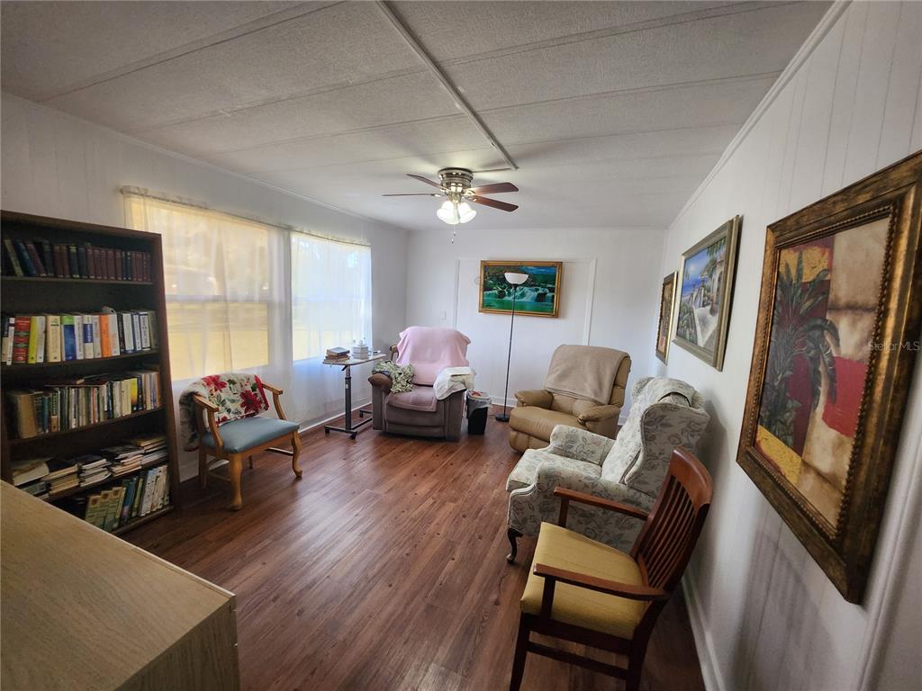 6091 Southeast 114th Street Road Belleview, FL 34420 - Photo 26 of 44 a living room with furniture a bookshelf and a window
