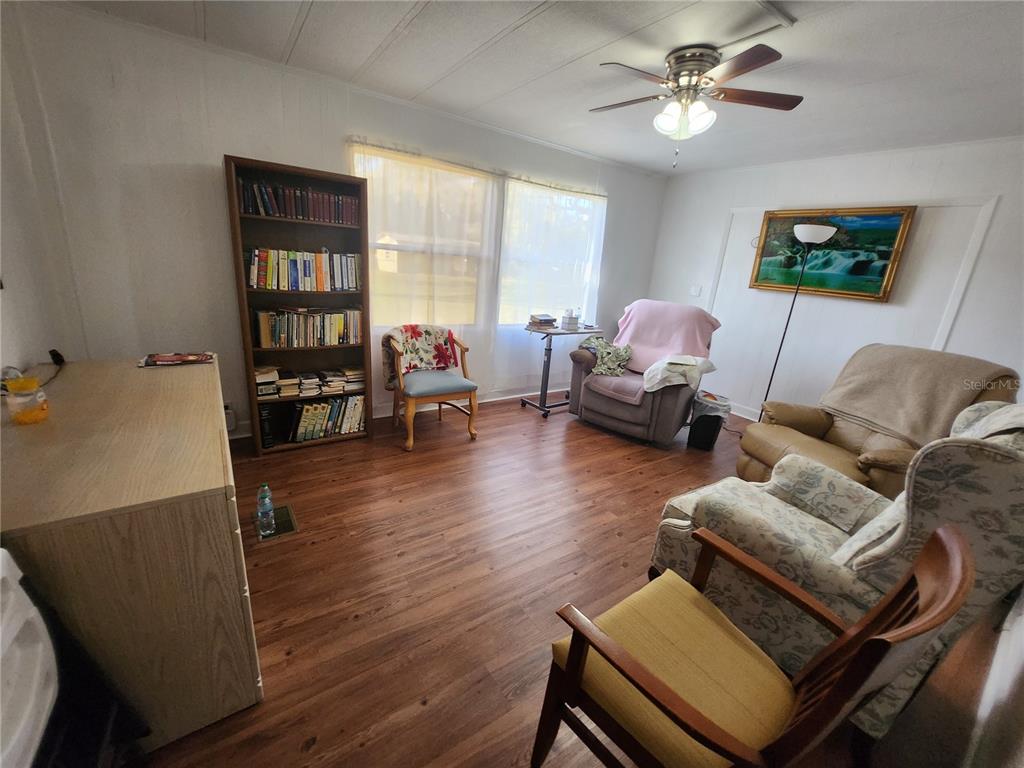 6091 Southeast 114th Street Road Belleview, FL 34420 - Photo 27 of 44 a living room with furniture a wooden floor and a window