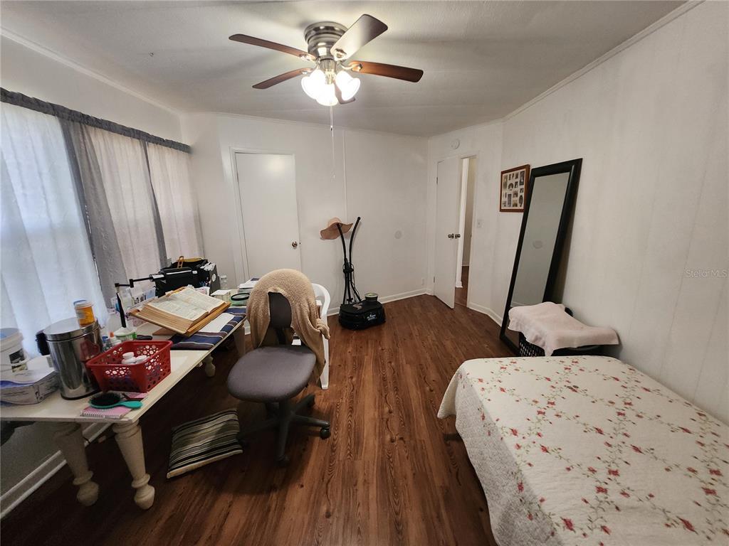 6091 Southeast 114th Street Road Belleview, FL 34420 - Photo 29 of 44 a bedroom with two beds and a chandelier