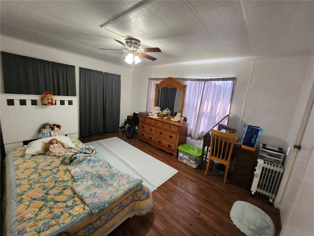 6091 Southeast 114th Street Road Belleview, FL 34420 - Photo 31 of 44 a bed room with furniture and wooden floor