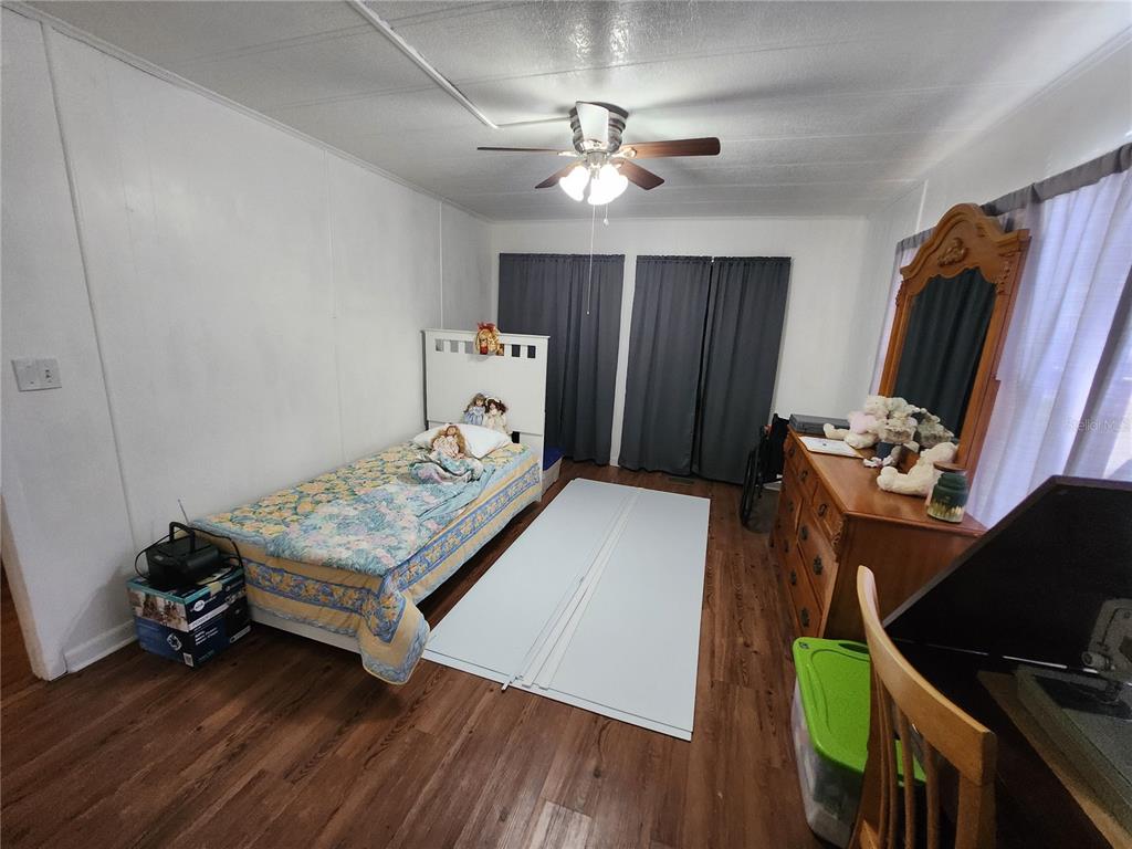 6091 Southeast 114th Street Road Belleview, FL 34420 - Photo 32 of 44 a bed room with furniture and a flat tv screen