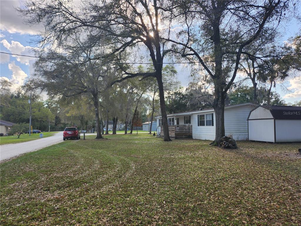 6091 Southeast 114th Street Road Belleview, FL 34420 - Photo 36 of 44 a view of a house with a yard and large trees
