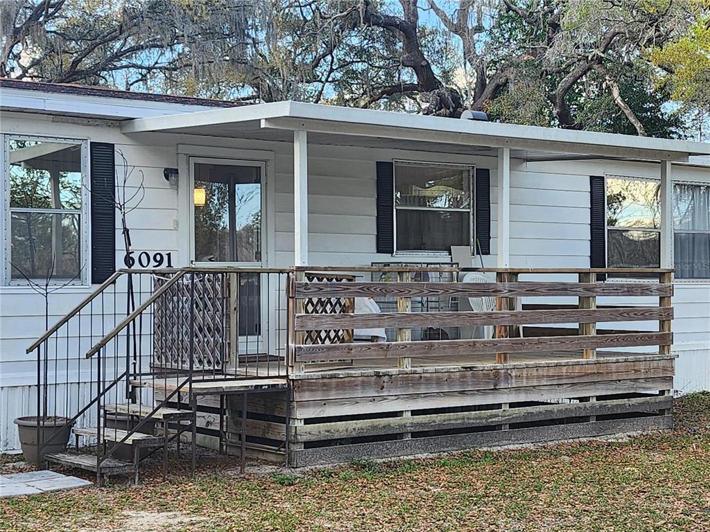 6091 Southeast 114th Street Road Belleview, FL 34420 - Photo 6 of 44 a view of a house with a large window and wooden fence