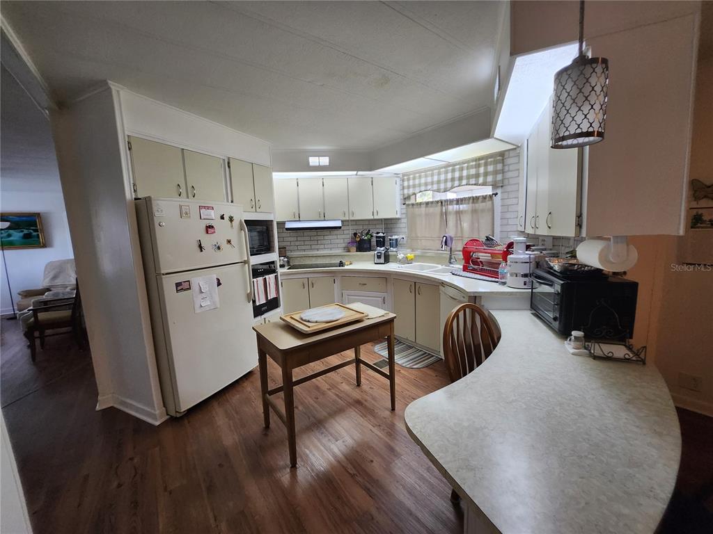 6091 Southeast 114th Street Road Belleview, FL 34420 - Photo 9 of 44 a living room with furniture a large window and wood floor