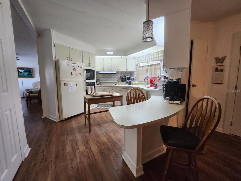 6091 Southeast 114th Street Road Belleview, FL 34420 - Photo 10 of 44 a dining room with furniture and wooden floor