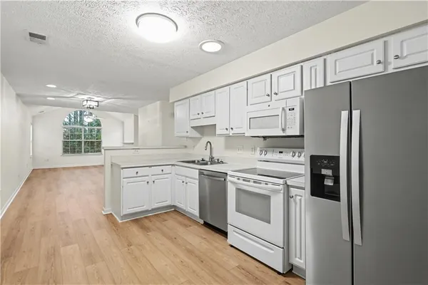a kitchen with white cabinets and stainless steel appliances