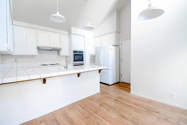 a kitchen with granite countertop a sink cabinets and stainless steel appliances
