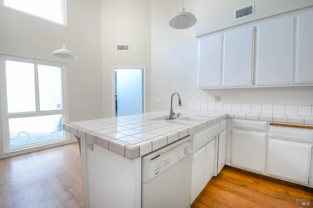a kitchen with a sink cabinets and wooden floor