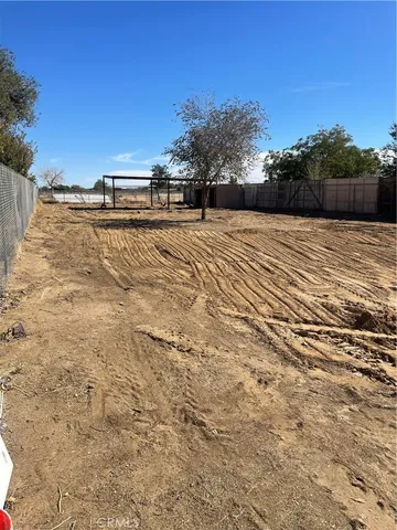 an empty room with wooden floor fireplace and windows