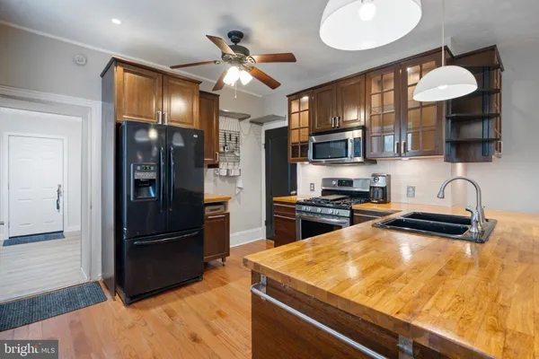 a kitchen with stainless steel appliances granite countertop a refrigerator and a stove top oven