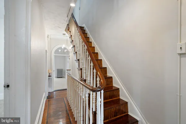 a view of staircase with wooden floor and white walls