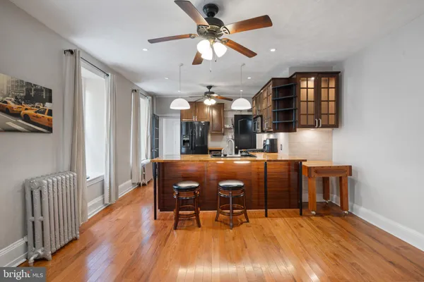 a room with stainless steel appliances lots of wooden furniture