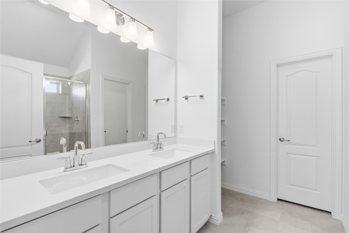 13609 Barn Chime Street Elgin, TX 78621 - Photo 7 of 14 a bathroom with 2 sink and a mirror