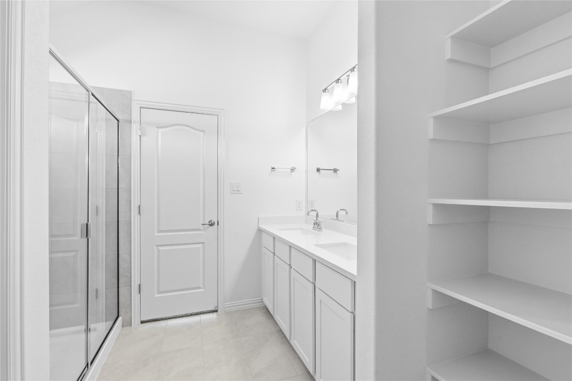 13609 Barn Chime Street Elgin, TX 78621 - Photo 8 of 14 a bathroom with a double vanity sink and mirror