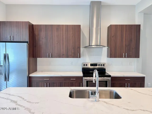 a kitchen with stainless steel appliances wooden cabinets sink and stove