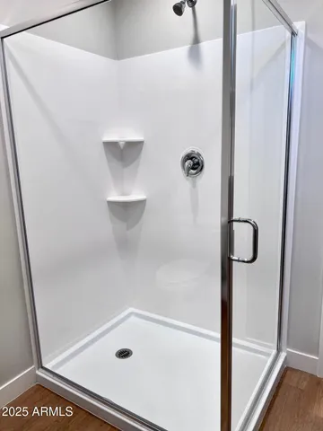 an empty room with wooden floor and a floor to ceiling window