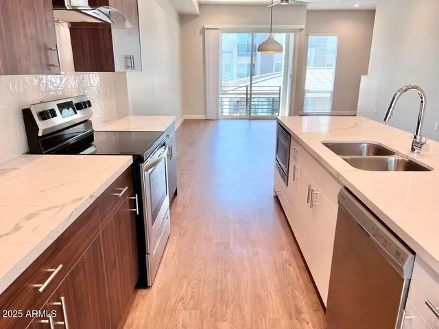 a kitchen with granite countertop a sink a counter top space and cabinets