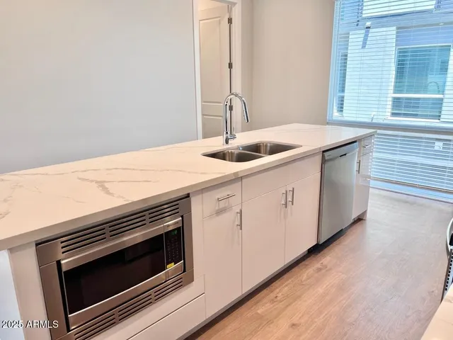 a kitchen with granite countertop white cabinets and white appliances