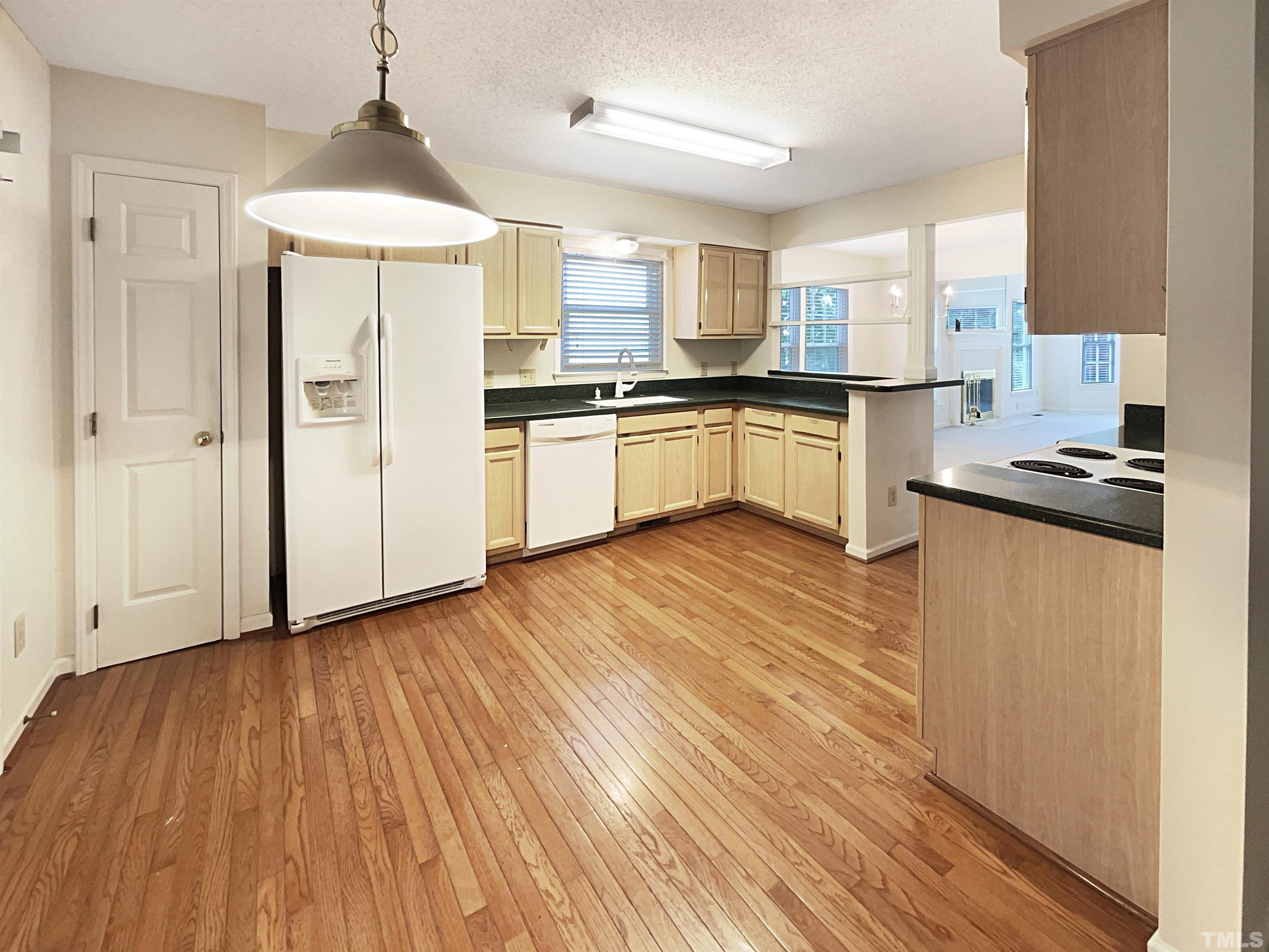 1749 Kingston Heath Way Raleigh, NC 27604 - Photo 2 of 19 a kitchen with granite countertop wooden floors stainless steel appliances and sink
