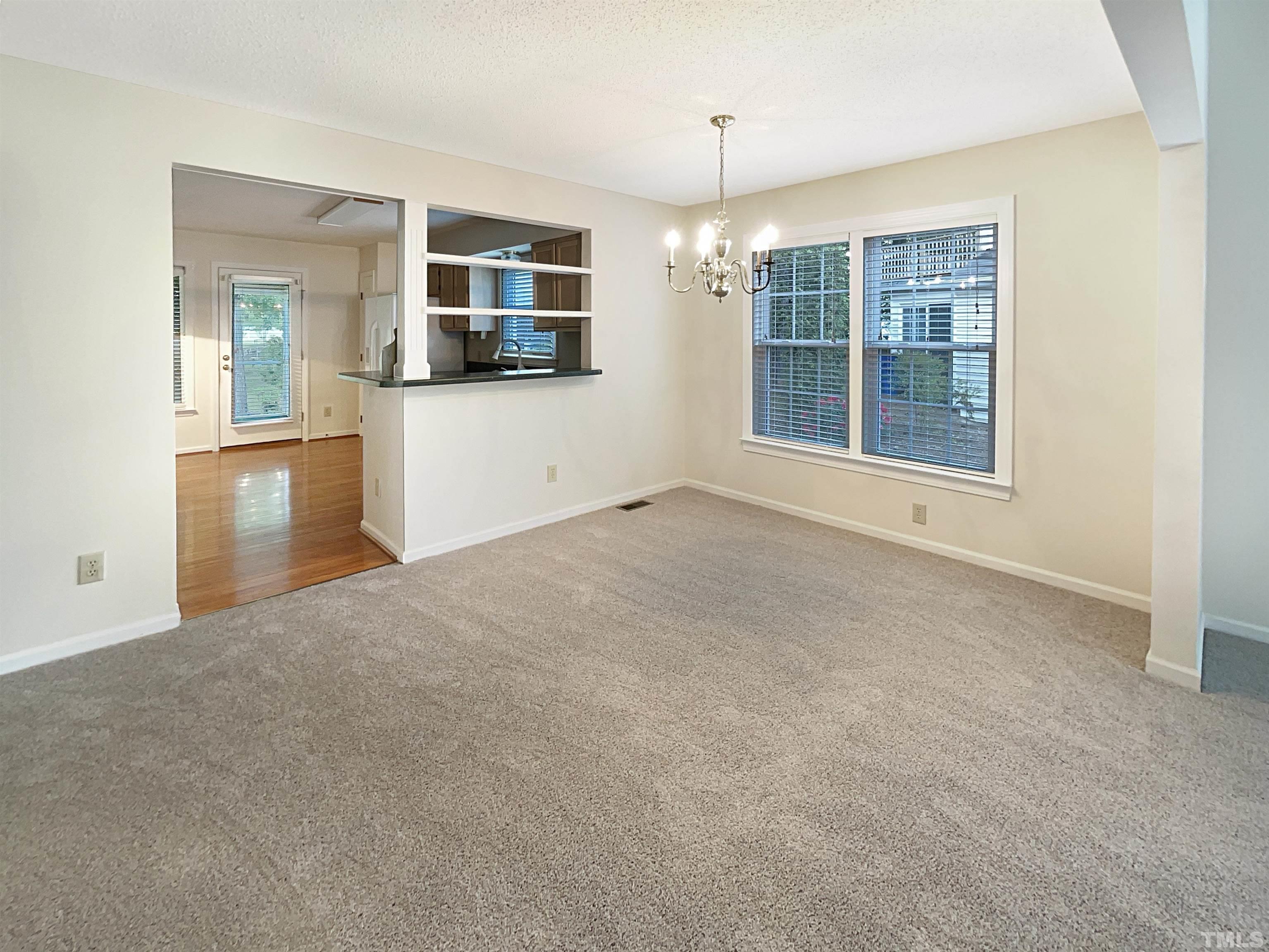 1749 Kingston Heath Way Raleigh, NC 27604 - Photo 9 of 19 an empty room with a kitchen and windows
