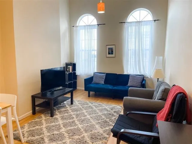 a living room with furniture a large window and a flat screen tv