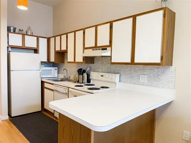 a kitchen with a white cabinets and a refrigerator