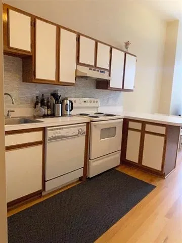 a kitchen with stainless steel appliances granite countertop a sink stove and cabinets