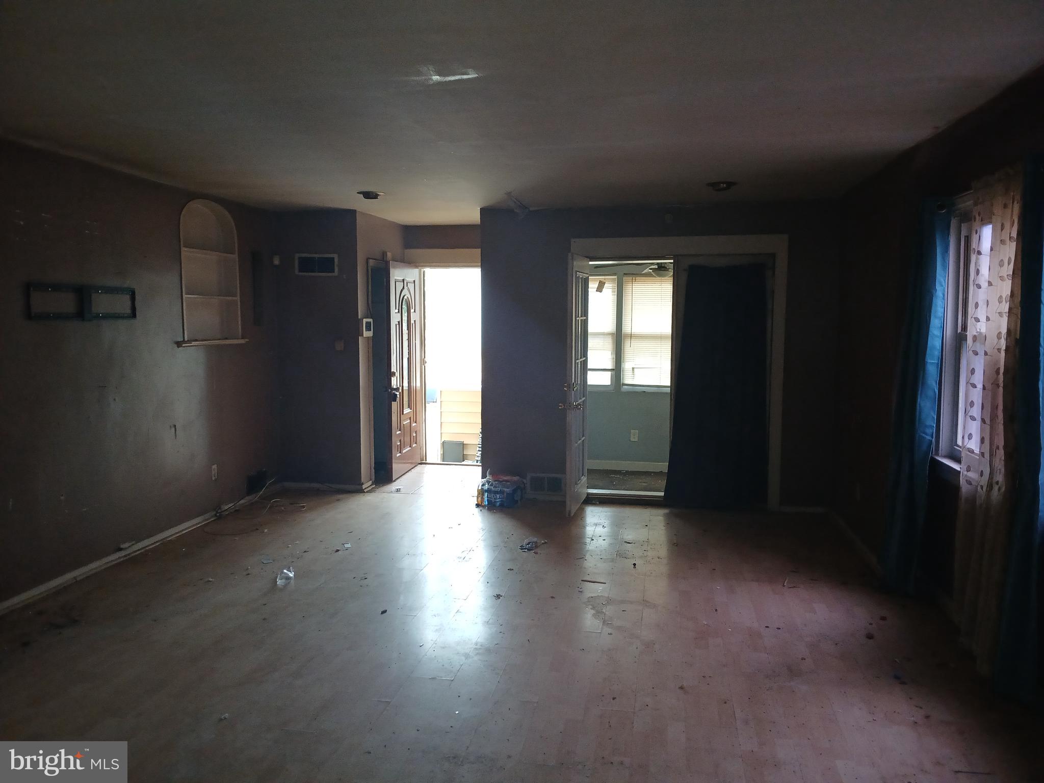 4003 Springdale Avenue Baltimore, MD 21207 - Photo 3 of 12 an empty room with wooden floor and windows